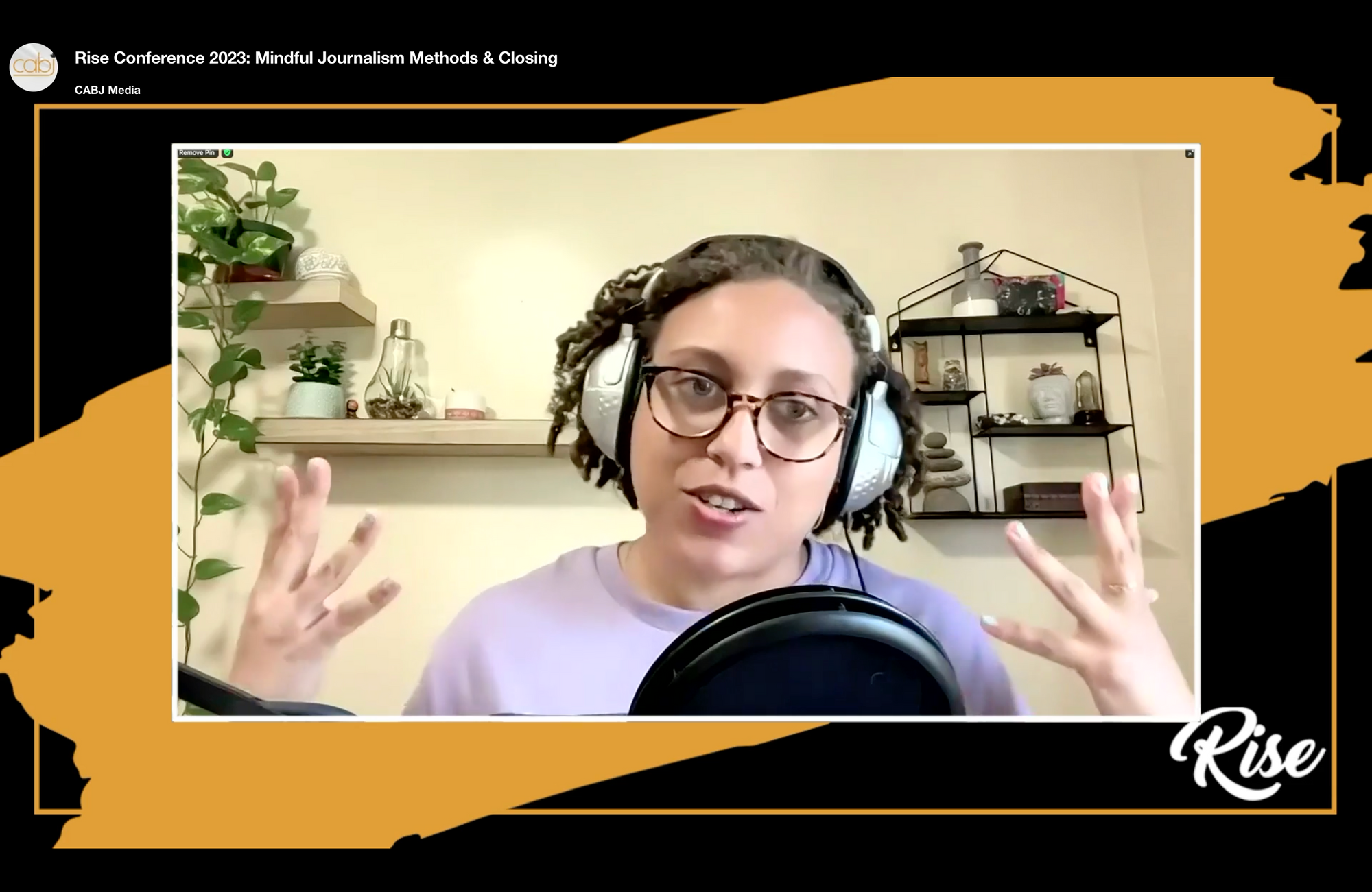 Twice As Good founder Sandra Hannebohm is seen presenting on Mindful Journalism Methods virtually at the RISE Conference for BIPOC journalists. On the wall behind her are various wall shelves with decorative objects and plants.